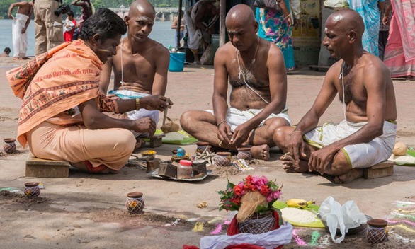 An Indian family participating in a traditional death ritual conducted by a priest