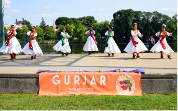 A group of people in white dresses dancing on a stage    Description automatically generated with low confidence